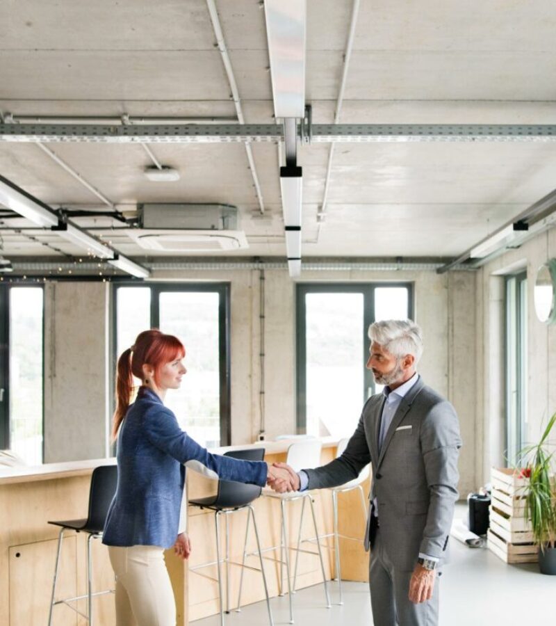 two-business-people-in-the-office-shaking-hands-PWRS4YC.jpg